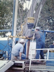 Ruffnecks make a connection (add pipe) on an air drilled well in the Arkoma, circa 1980s